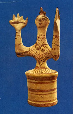 clay figure with arms in orans
